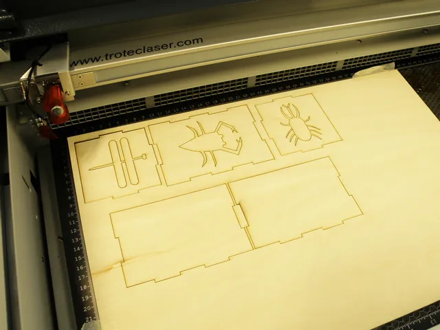 Trotec laser cutter engraving insect and box designs on wooden sheet