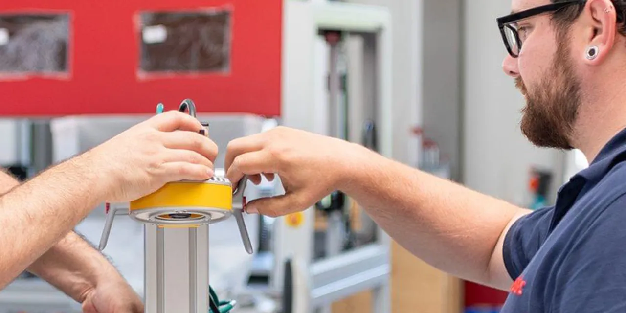 Técnicos de Trotec ensamblando un componente para una máquina de grabado láser en las instalaciones de fabricación