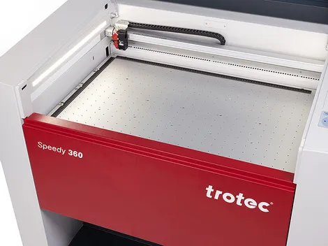 Pengukir laser Trotec Speedy 360 CO₂ dengan area kerja terbuka dan kepala laser yang terlihat