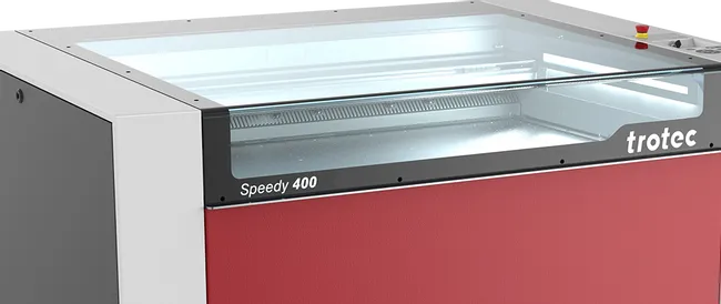 Máquina de grabado láser Trotec Speedy 400 CO₂ con tapa transparente sobre ruedas giratorias