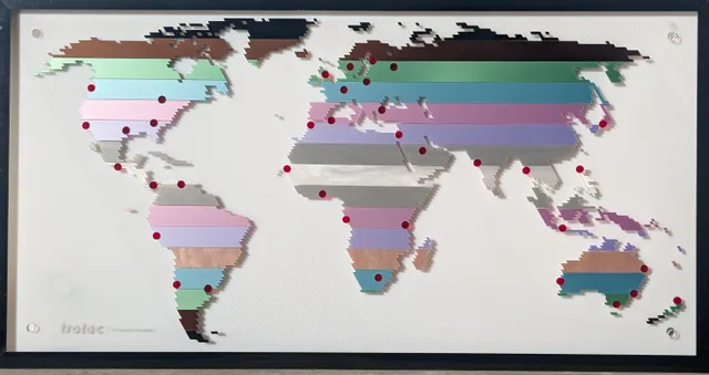 Colorful world map engraved on acrylic using Trotec laser cutter with red markers at global locations