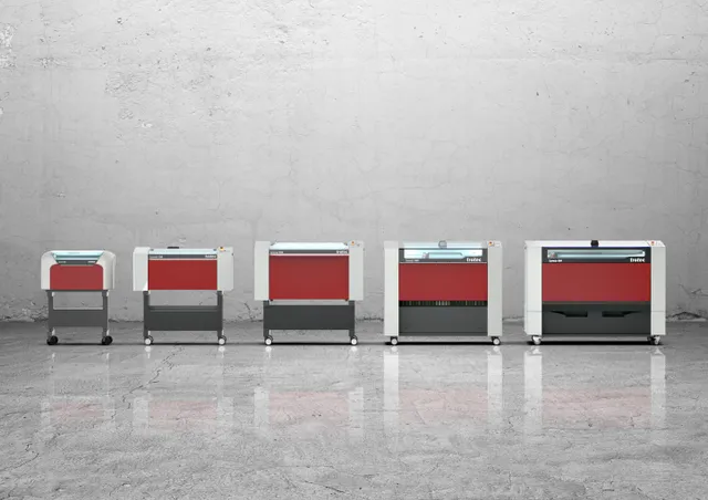 Alineación de cortadoras y grabadoras láser de CO₂ de la serie Speedy de Trotec sobre fondo de muro de hormigón.