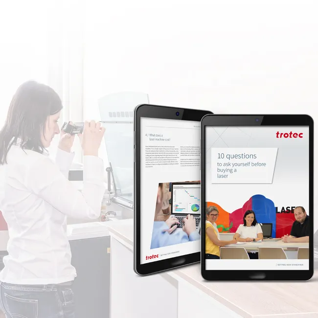 Panduan pembelian laser Trotec ditampilkan pada tablet di dekat penyiapan pemotong laser CO₂