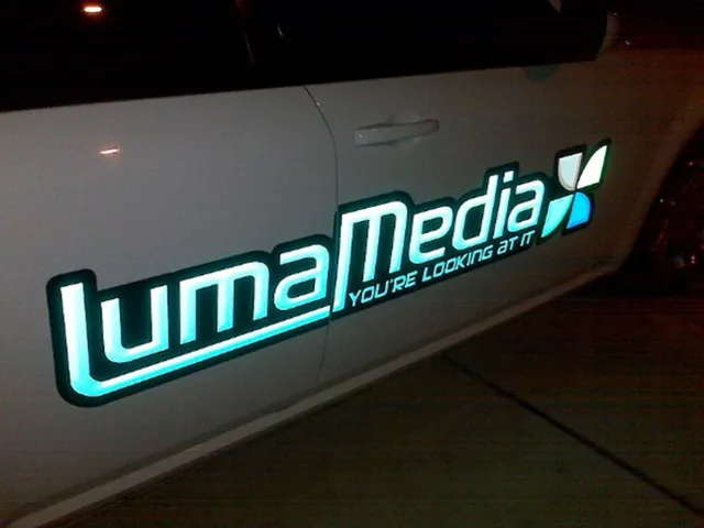 Illuminated LumaMedia car door graphic showcasing glowing laser-cut signage