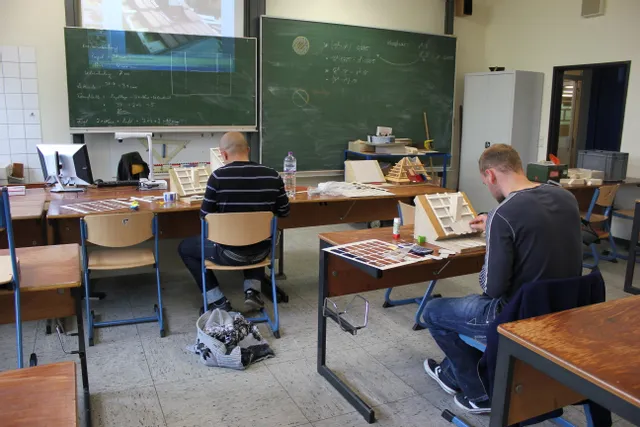 Studenten beim Zusammenbau von Architekturmodellen im Klassenzimmer mit lasergeschnittenen Teilen, wahrscheinlich vom Trotec Laserschneider