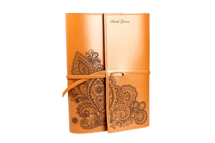 Cubierta de cuaderno de cuero intrincadamente grabada con diseño floral utilizando la cortadora láser Trotec CO₂.
