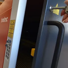 オペレーターが安全対策キーでSpeedyシリーズCO₂レーザーカッターのロックを解除している様子。