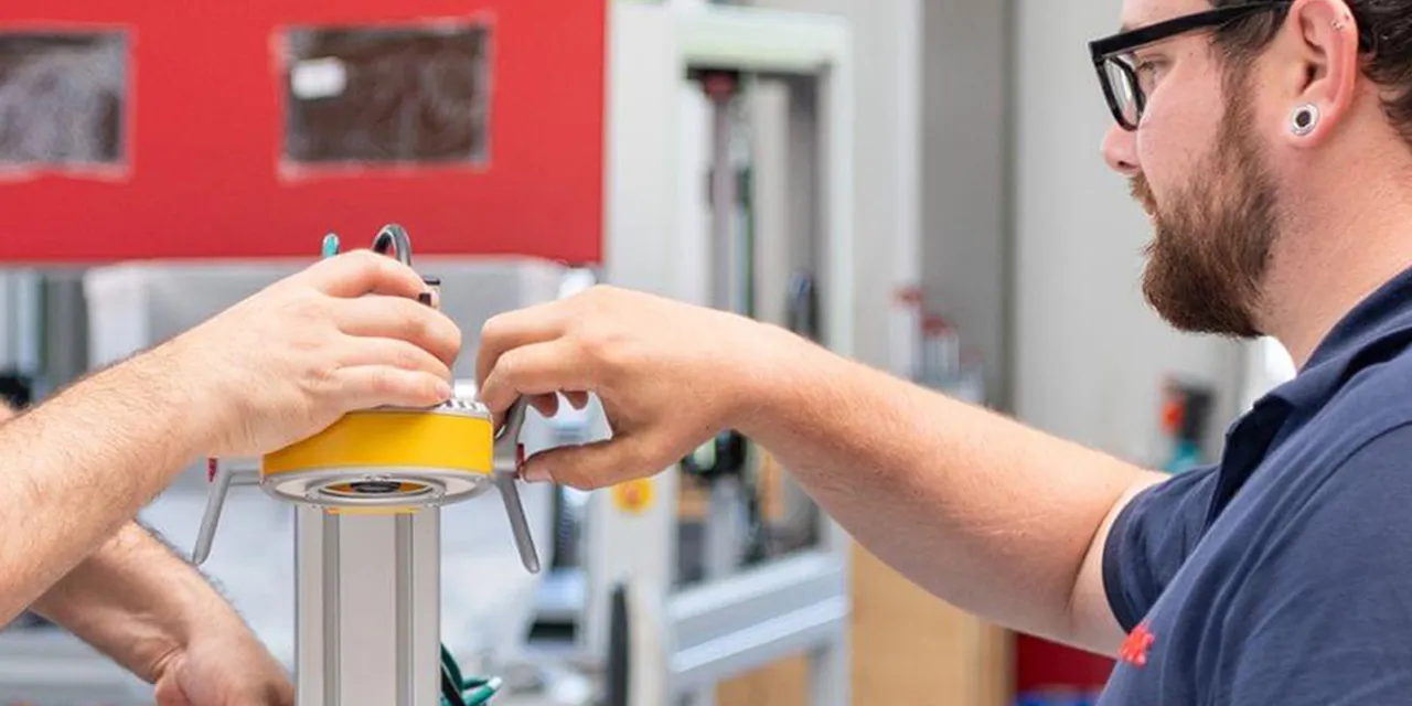 I tecnici di Trotec assemblano il componente per la macchina per l'incisione laser nello stabilimento di produzione.