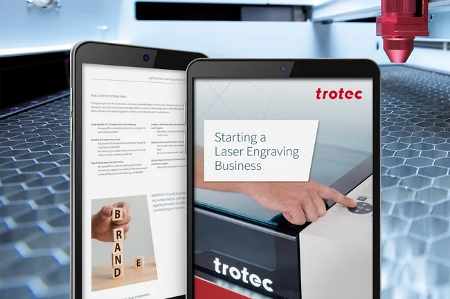 Máquina de corte a laser Trotec com guia digital sobre como iniciar um negócio de gravação a laser exibido em tablets