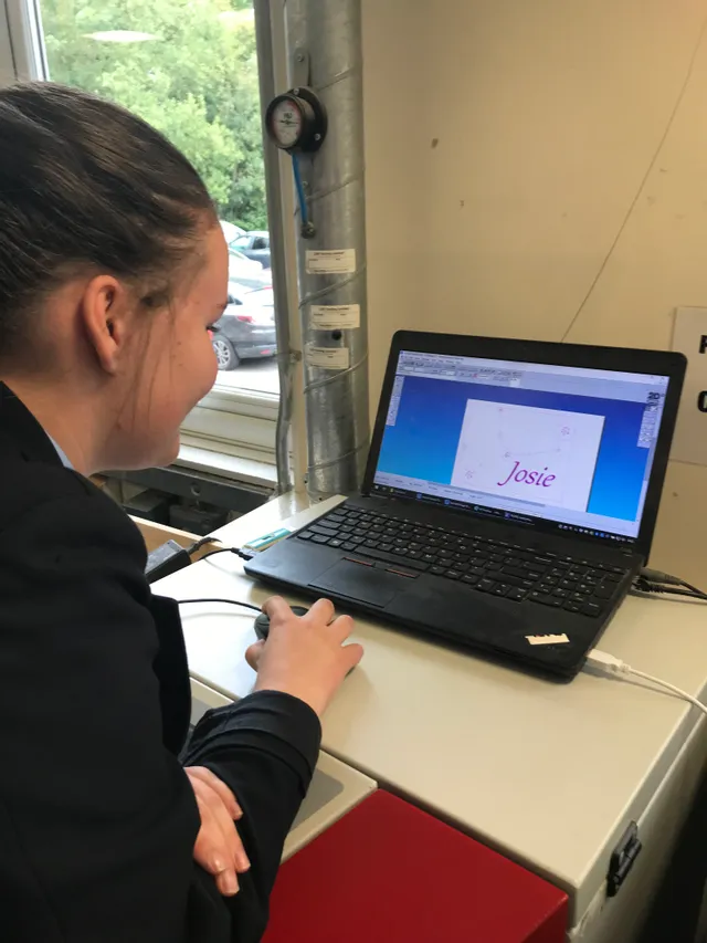 Studentin entwirft Textgravur auf Trotec Laserschneider Software mit Laptop