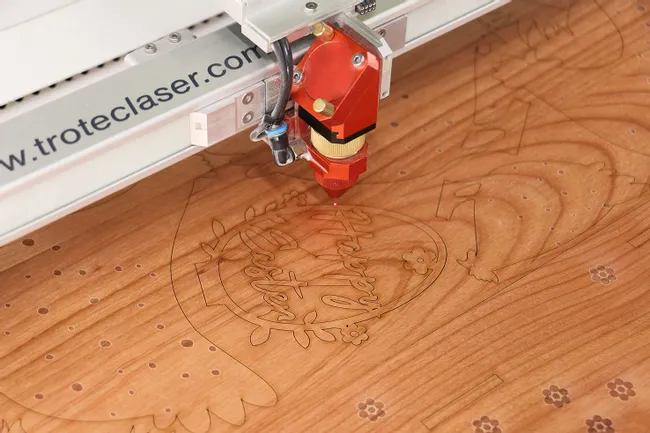 Trotec CO₂ machine de gravure laser gravure du motif Joyeuses Pâques sur surface en bois.