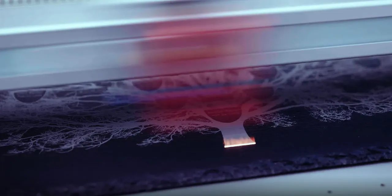 Trotec Laserschneider graviert detailliertes Baumdesign auf schwarzem Material mit CO₂-Laser