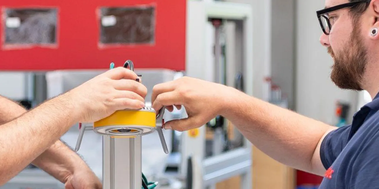 Trotec technicians assembling component for laser engraving machine in manufacturing facility