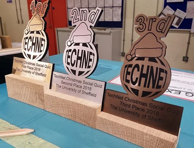 Lasergeschnittene Holztrophäen für das TechNet-Quiz, hergestellt mit einer Lasergraviermaschine von Trotec CO₂