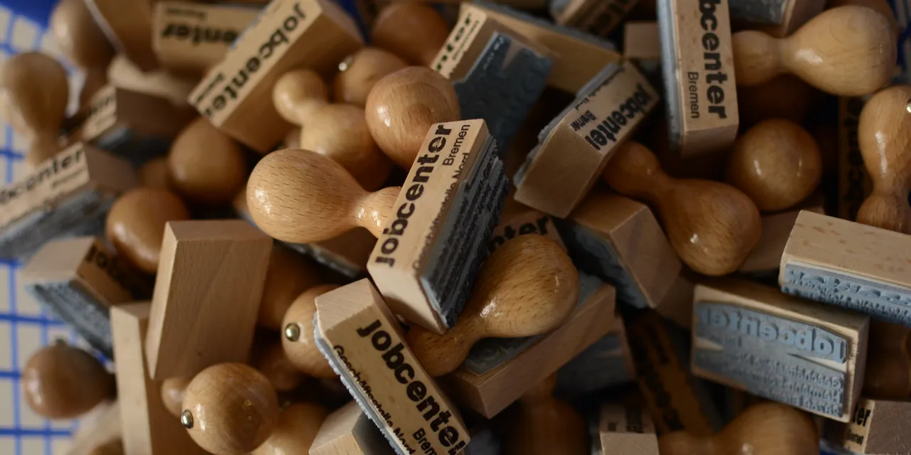 Pile of wooden stamps engraved with jobcenter logos, likely made using Trotec laser engraver