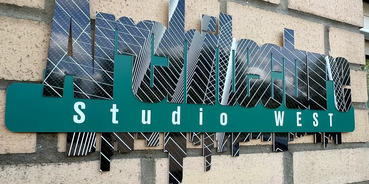 Laser-cut architectural sign made with Trotec laser cutter for Studio West on brick wall