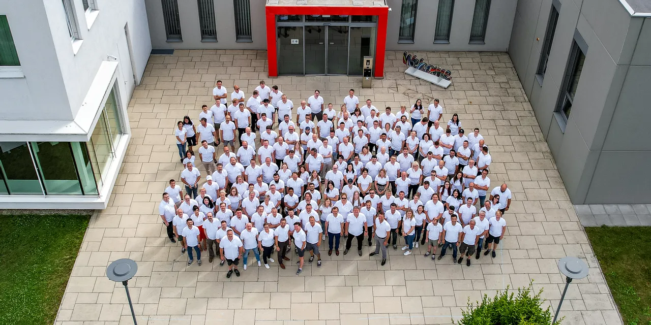 Trotec team group photo outside company building, celebrating laser technology innovation