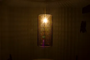 Abat-jour cylindrique découpé au laser et projetant une lumière à motifs, réalisé avec la machine de découpe laser Trotec CO₂.