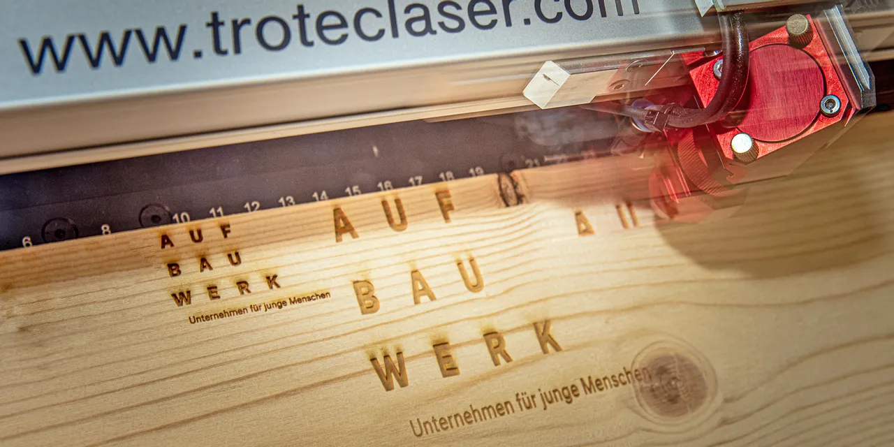 Trotec CO₂ laser engraver etching text onto wooden surface with high precision