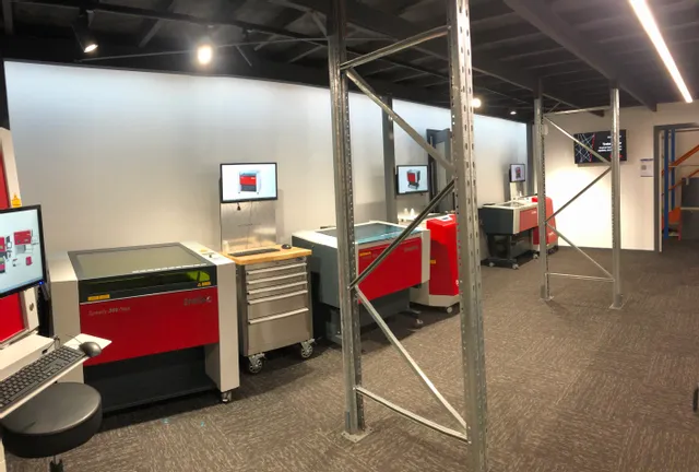 Trotec Speedy series laser cutters and engraving machines in a demo showroom with Ruby software screens