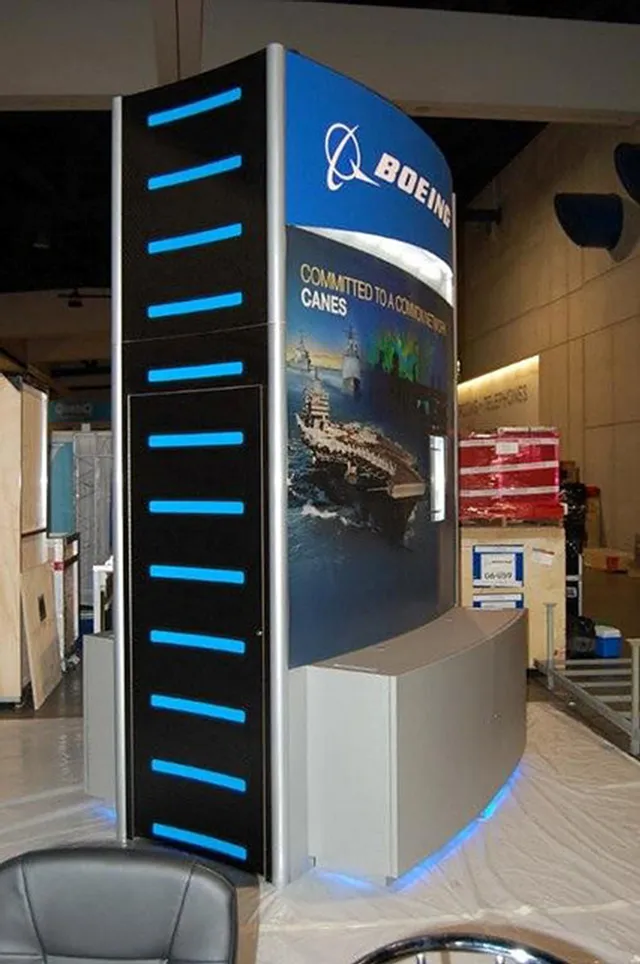 Trade show booth featuring Boeing naval defense display with blue accent lighting