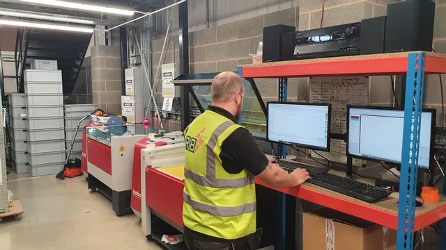 Operator using Trotec Speedy series CO₂ laser cutter with Ruby software in industrial workspace