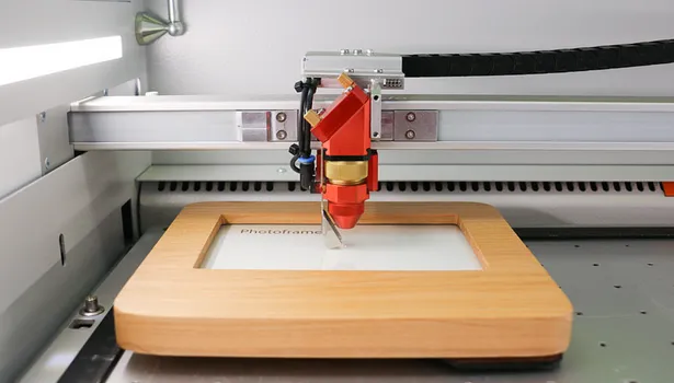 Trotec laser cutter engraving text on wooden photo frame with CO₂ laser technology