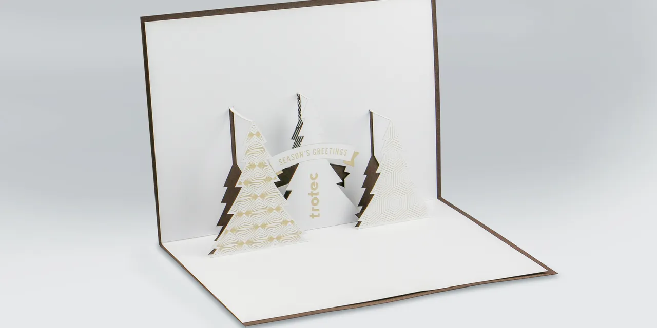 Biglietto natalizio tagliato al laser con alberi pop-up realizzati con la taglierina laser Trotec