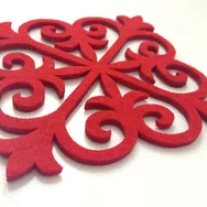 Intrincado patrón de fieltro rojo cortado con la cortadora láser Trotec CO₂ para uso decorativo.