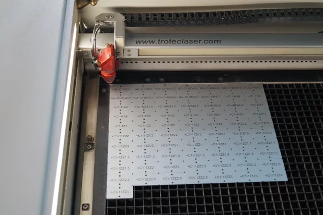 La machine laser Trotec grave des codes de série sur des tôles grâce à la technologie laser CO₂.