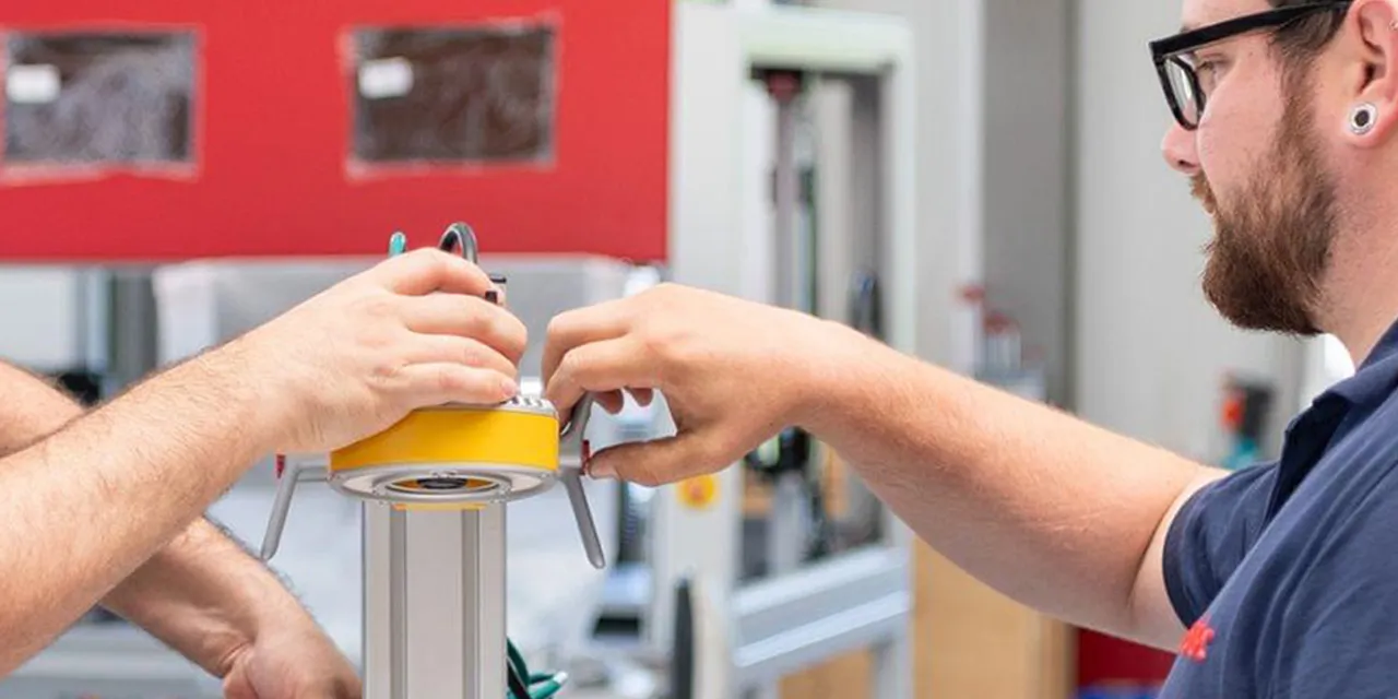 Trotec technicians assembling component for laser engraving machine in manufacturing facility