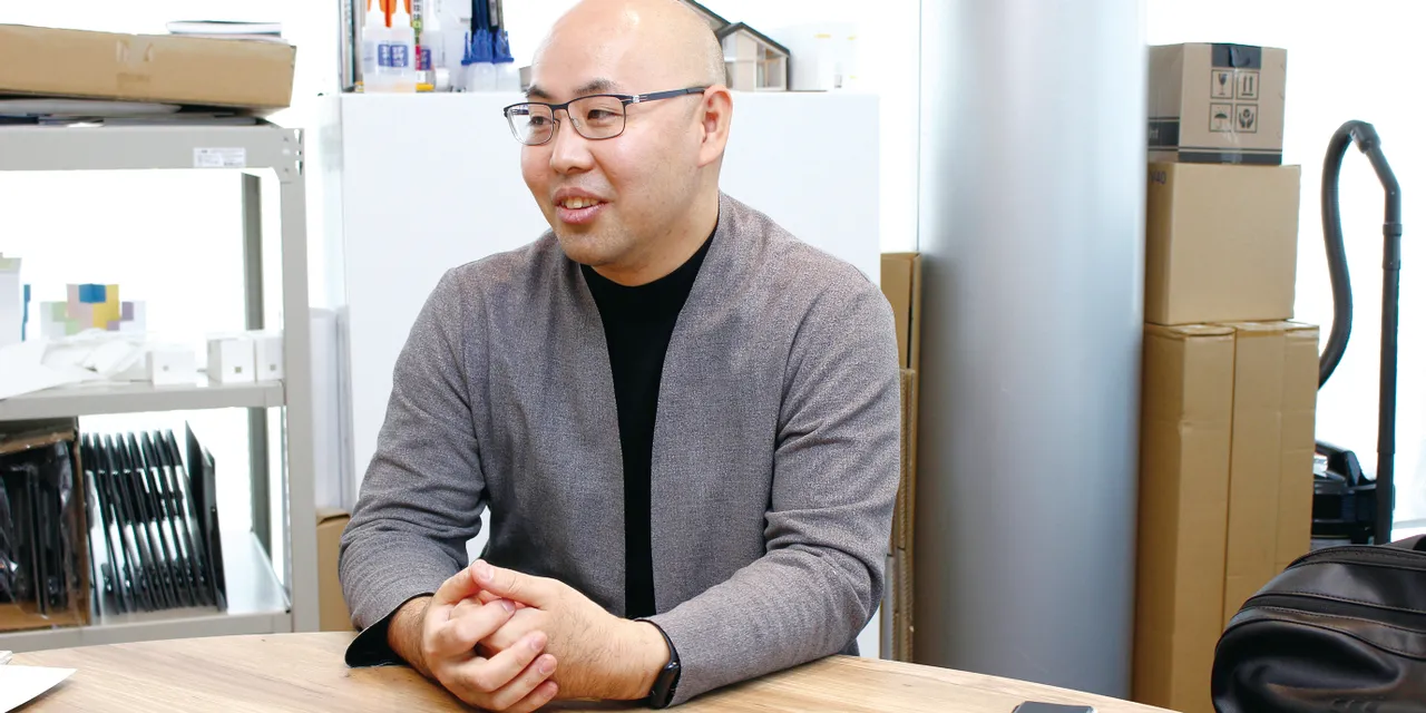 Man sitting at desk in modern workspace with tablet, discussing Trotec laser engraving technology