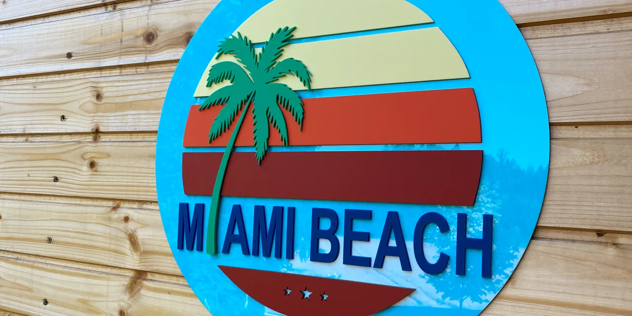 Panneau Miami Beach en acrylique superposé créé avec la machine de découpe laser Trotec sur un mur en bois.
